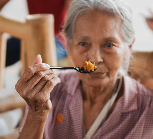 Close-up portrait of woman eating food at home