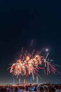 Low angle view of firework display at night