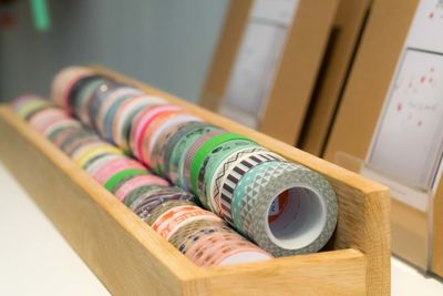 Close-up of colorful adhesive tapes in wooden container