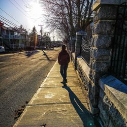 Rear view of man walking on zebra crossing