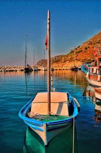 Sailboats moored on lake against sky