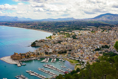 High angle view of townscape by sea against sky