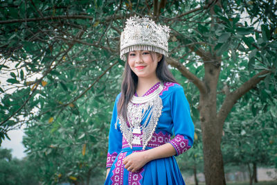 Portrait of a smiling girl standing against plants