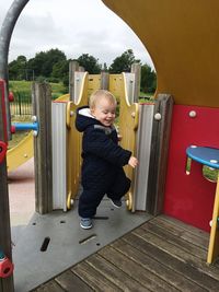 Smiling toddler playing at jungle gym