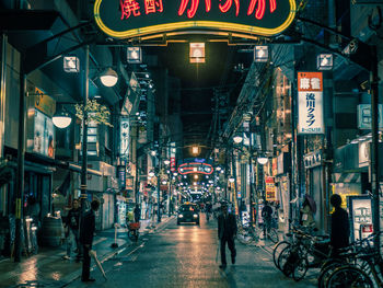 People in illuminated city at night