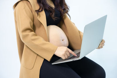 Midsection of woman holding mobile phone