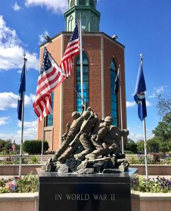 Statue of flags against cloudy sky