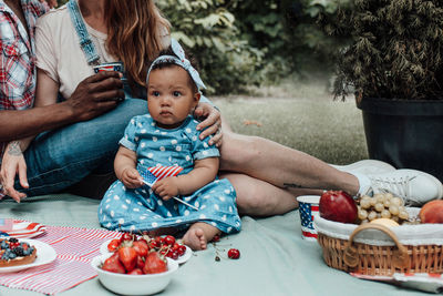 Full length of mother and daughter sitting on wicker basket