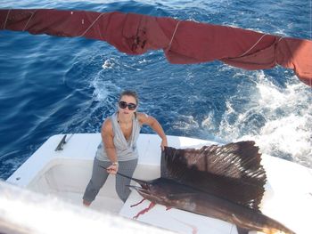 High angle portrait of woman with fish in boat sailing in sea