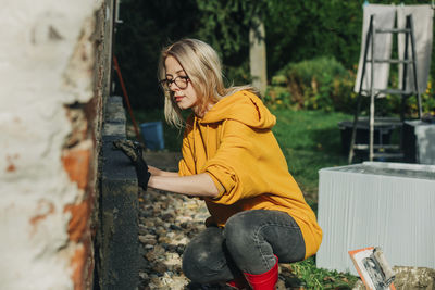 Young woman installing polystyrene on wall