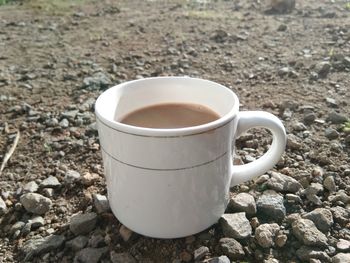 Close-up of coffee cup on rock