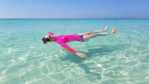 Full length of girl in sea against clear sky