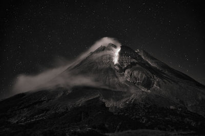 Low angle view of snowcapped mountain against sky at night