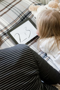 Girl with grandmother using digital tablet