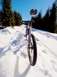 Bicycle parked on snow covered land