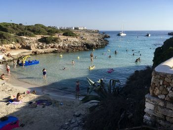 People on beach against clear sky