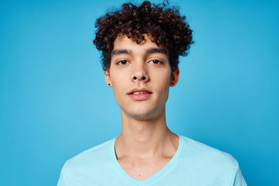 Portrait of young man against blue background