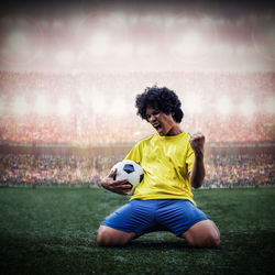 Man playing soccer ball on grass at night