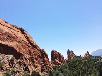 Low angle view of rocky mountains against clear sky