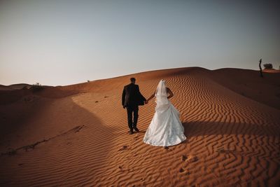 People on sand dune at desert