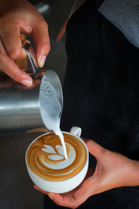 Midsection of man holding coffee cup