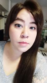 Close-up portrait of young woman at home