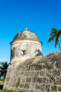 Low angle view of castle against clear blue sky on sunny day