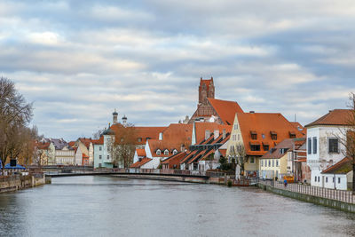 River amidst buildings in town against sky