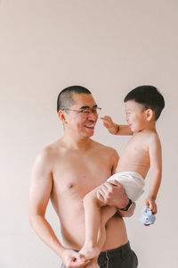 Full length of father and son against white background