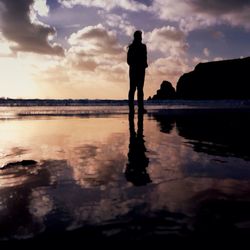 Silhouette of people in sea at sunset