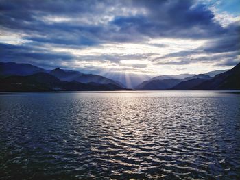 Scenic view of lake by mountains against sky