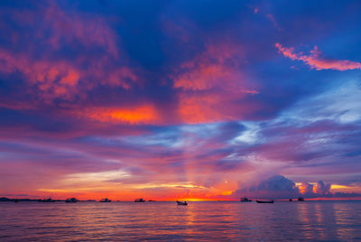 Scenic view of sea against dramatic sky during sunset