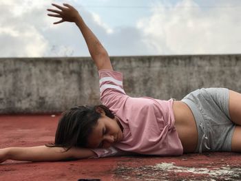 Young woman lying on building terrace