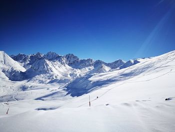 Scenic view of snowcapped mountains against clear blue sky