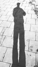 Shadow of man standing on cobblestone