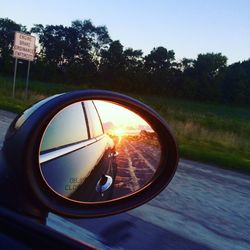 Reflection of man on side-view mirror