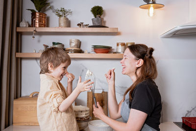 Family fun in the kitchen. mother and son baking carrot cake together. scandinavian kitchen interior