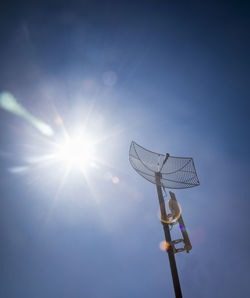 Low angle view of floodlight against blue sky