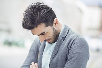 Sad businessman looking down outdoors