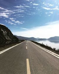 Empty road against cloudy sky