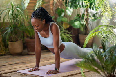 Side view of young woman exercising in park