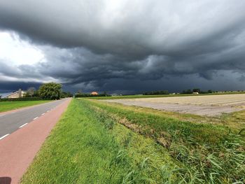 Scenic view of field against cloudy sky