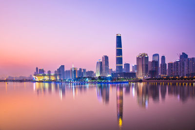 Illuminated buildings against sky during sunset