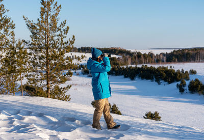 Full length of woman skiing on snow covered field