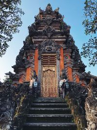 Low angle view of temple amidst building against sky