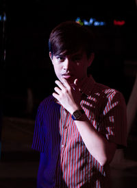 Portrait of young man standing in darkroom