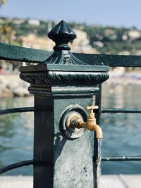 Close-up of metal railing against water