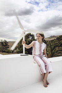 Girl looking at small wind turbine on white wall