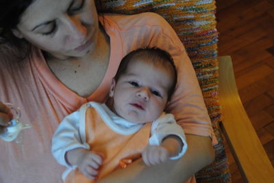 High angle view of mother sitting with toddler son on chair