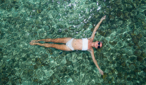 High angle view of man lying in sea